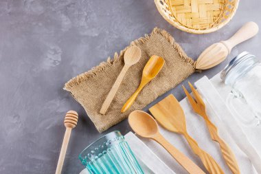 Sıfır atık. Eko çanta, cam ve gri arka planda ahşap çatal bıçak. Çevre dostu ahşap çatal bıçak takımı, çuval bezi ve mason kavanozu. Plastiksiz konsept. Üst Manzara. Boşluğu kopyala