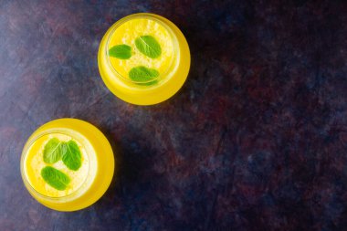 Arka planda ananas kokteyli. Naneli soğuk ananas kokteyli. Siyah arka planda yaz tropik kokteyli. Sağlıklı bir içki. Üst Manzara. Boşluğu kopyala