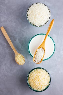 Gri arka planda pirinç sütü. Bardakta pirinç sütü ve pirinç tohumları. Çimento arka planında süt içermeyen vegan. Yükselişten gelen alternatif süt. Minimalizm. Boşluğu kopyala