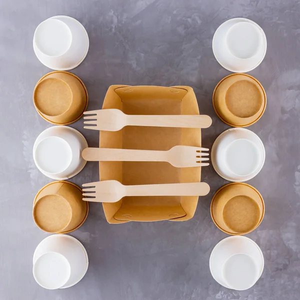 Zero waste. Disposable tableware. Eco-friendly disposable utensils made of bamboo wood and paper on a gray background. Paper cups, fast food containers and bamboo wooden cutlery