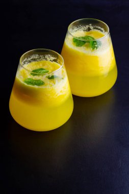 Arka planda ananas kokteyli. Naneli soğuk ananas kokteyli. Siyah arka planda yaz tropik kokteyli. Sağlıklı içecek.