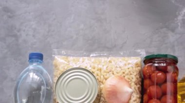 Gri arka planda gıda bağışları. Coronavirus sırasında gıda bağışı (COVID-19). Teslimat konsepti. Üst görünüm