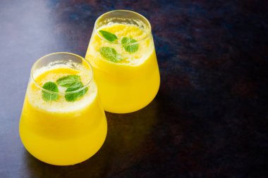 Karanlık bir arka planda ananas suyu. Bardakta detoks sıvısı var. Taze ananaslı ananas püresi. Siyah arka planda yaz içkisi. Üst Manzara. Boşluğu kopyala