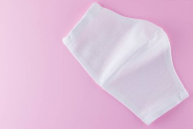 Pembe arka planda koruyucu gazlı bez maskesi. Beyaz antivirüs maskesi. Pamuktan yapılmış el yapımı tıbbi maske. Gazlı bezden yapılmış koruyucu yüz maskesi. Üst Manzara. Boşluğu Kopyala
