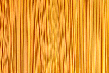 Sarı makarna arka planı. Kuru spagetti arka planı. Çiğ spagetti duvar kağıdı. Yemek geçmişi konsepti. Üst görünüm