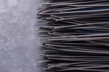 Gri arka planda siyah makarna. Çimento arka planında siyah spagetti. Mürekkepbalıklı çiğ spagetti. Yemek geçmişi konsepti. Üst Manzara. Boşluğu kopyala