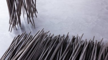 Gri arka planda siyah makarna. Çimento arka planında siyah spagetti. Mürekkepbalıklı çiğ spagetti. Yemek geçmişi konsepti. Üst Manzara. Boşluğu kopyala