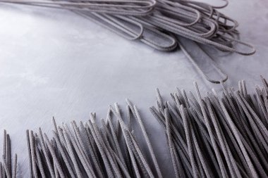 Gri arka planda siyah makarna. Çimento arka planında siyah spagetti. Mürekkepbalıklı çiğ spagetti. Yemek geçmişi konsepti. Üst Manzara. Boşluğu kopyala