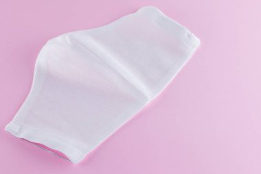 Pembe arka planda koruyucu gazlı bez maskesi. Beyaz antivirüs maskesi. Pamuktan yapılmış el yapımı tıbbi maske. Gazlı bezden yapılmış koruyucu yüz maskesi. Üst Manzara. Boşluğu Kopyala