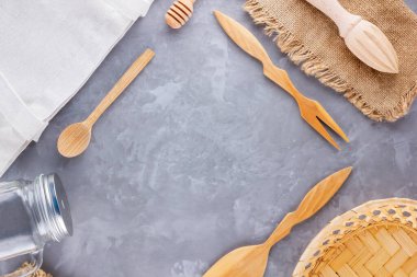 Sıfır atık. Eko çanta, cam ve gri arka planda ahşap çatal bıçak. Çevre dostu ahşap çatal bıçak takımı, çuval bezi ve mason kavanozu. Plastiksiz konsept. Üst Manzara. Boşluğu kopyala