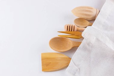 Sıfır atık. Beyaz arka planda pamuk çanta ve ahşap çatal bıçak takımı. Çevre dostu ahşap çatal bıçak takımı ve ekolojik çanta. Plastiksiz konsept. Minimalizm. Boşluğu kopyala