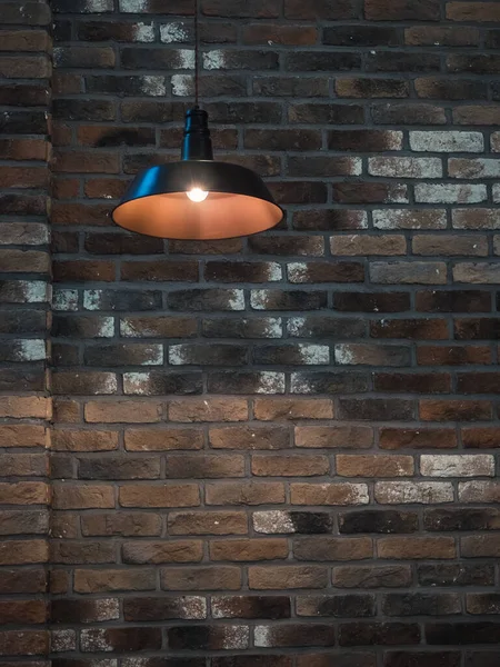 pendant lamp on the background of an old brick wall - part of the interior in the loft style