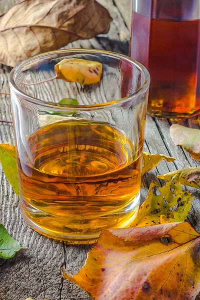 Glas whiskey in de herfst bladeren — Stockfoto