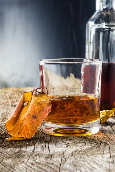 Glas whiskey in de herfst bladeren — Stockfoto