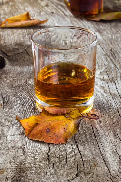 Glas whiskey in de herfst bladeren — Stockfoto