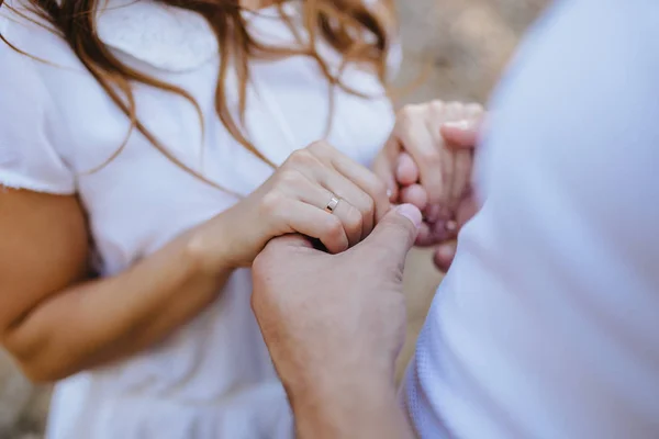 Любовники держатся за руки с золотыми обручальными кольцами — стоковое фото