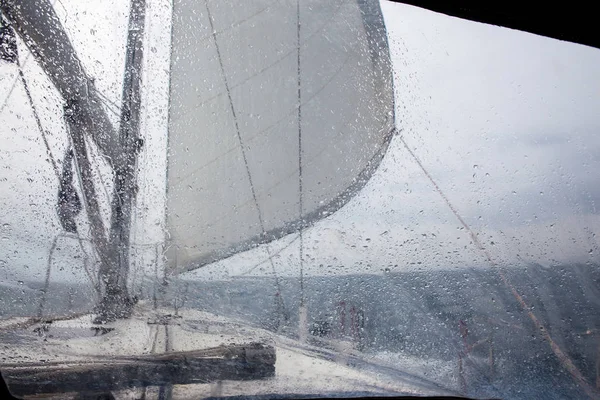 View through the glass with raindrops  sailing yacht — Stock Photo, Image