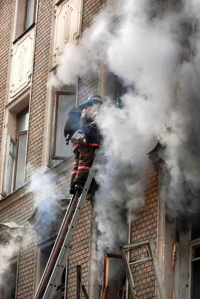 Bombero apaga un incendio en un edificio de apartamentos —  Fotos de Stock