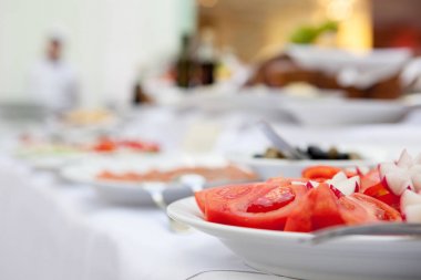 Bir domates ve bir turp beyaz bir tablo üzerinde sebze salatası.