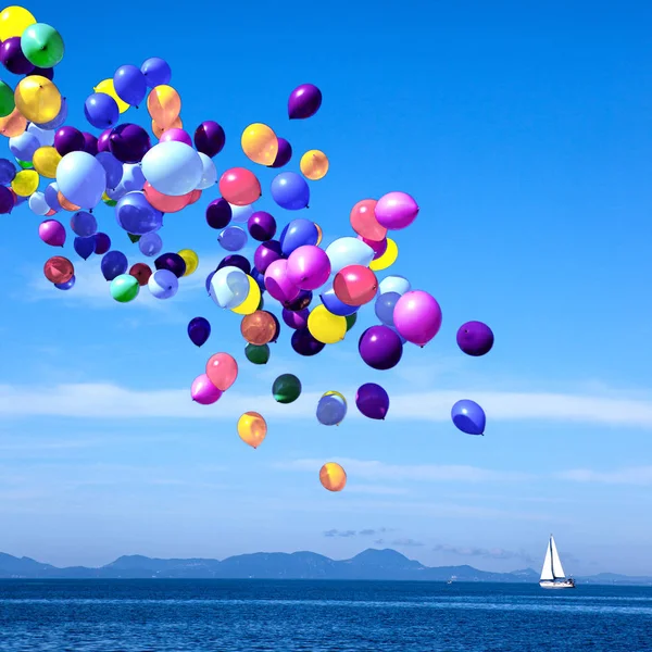 Balões coloridos à deriva sobre o mar azul calmo . — Fotografia de Stock