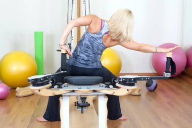 Spor salonunda egzersiz yapan genç bir kadın.