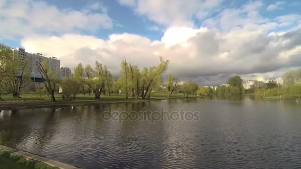Panorama d'un parc verdoyant avec un lac à Moscou. Le ciel expressif se reflète dans l'eau .