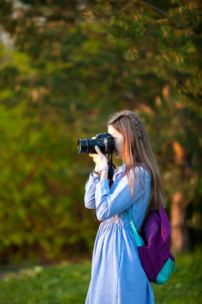 Vacker ung flicka tar bilder i skogen. Flickan med kameran. Turist. Solnedgång. — Stockfoto