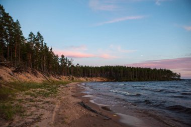 Kuzey deniz manzarası göl Onega Gölü üzerinde-batan güneşin ışınlarını yansıtan granit kıyıya dalgalar yendi.