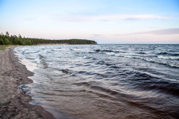 Északi-tengeri kilátás a tó Onega - hullámok verte a gránit partra, amely tükrözi a lenyugvó nap sugarai ellen. — Stock Fotó