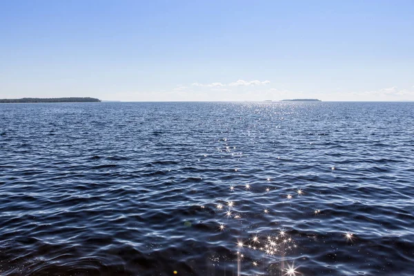 Északi-tengeri kilátás a tó Onega - hullámok verte a gránit partra, amely tükrözi a lenyugvó nap sugarai ellen. — Stock Fotó