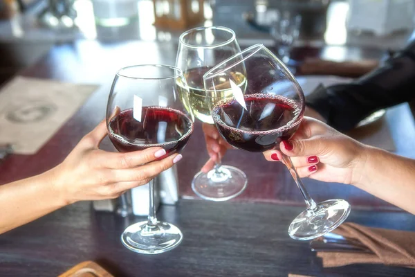 Happy friends in a bar drinking red wine. — Stock Photo, Image