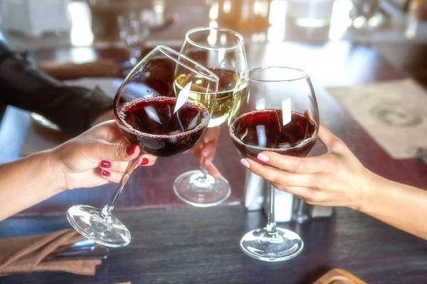 Happy friends in a bar drinking red wine. — Stock Photo, Image