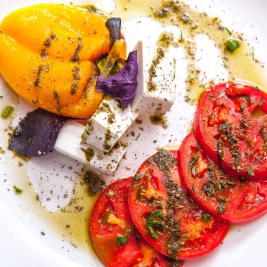 Rucola restoranda, closeup ahşap bir masa üzerinde beyaz bir tabakta domates, İtalyan otlar ile mozzarella