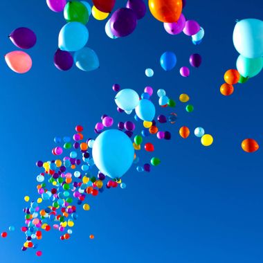 Renkli balonlar gökyüzünde uçan parti