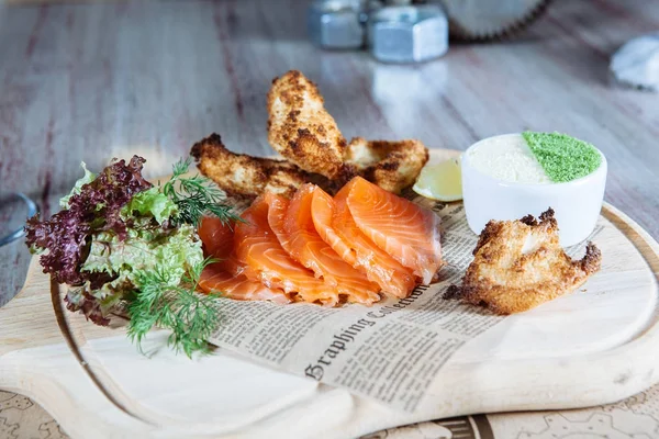 Plato de pescado y aves de corral en una mesa de madera en restaurante — Foto de Stock