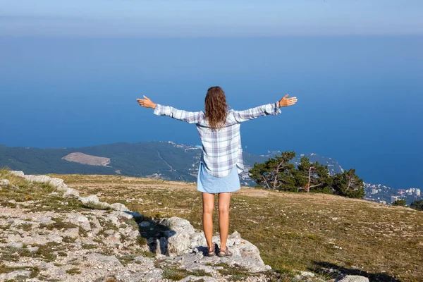 Joven mochilero de pie en la cima de una montaña y disfrutando de una vista del valle de la mañana — Foto de Stock