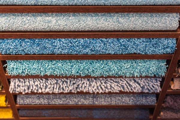Samples of multi-colored carpets on the shelves — Stock Photo, Image