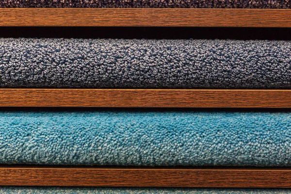Muster von bunten Teppichen in den Regalen — Stockfoto
