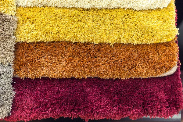 Amostras de tapetes multicoloridos nas prateleiras — Fotografia de Stock
