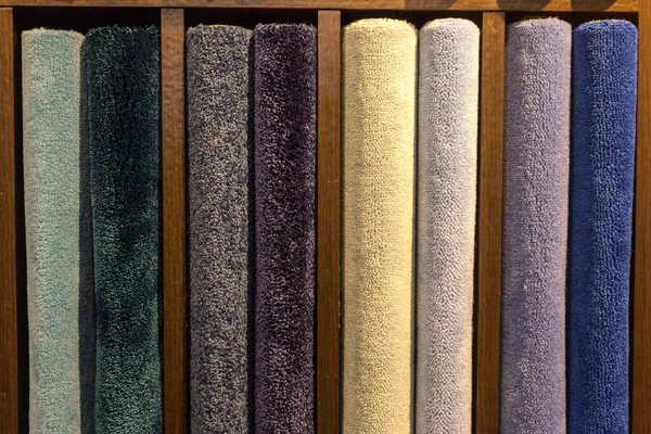 Samples of multi-colored carpets on the shelves — Stock Photo, Image