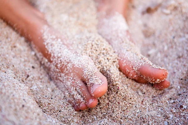 Pés de uma jovem na areia perto do oceano close-up — Fotografia de Stock
