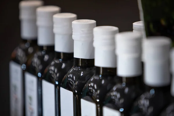 Ряды бутылок с оливковым маслом в уменьшающейся перспективе — стоковое фото