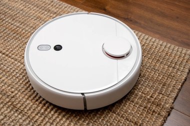 Robotik elektrik süpürgesi odayı toz ve enkazdan temizliyor, teknolojik ilerleme..