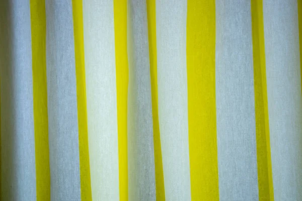 Creased striped yellow and white cloth material fragment as a background. the curtain in the room — 스톡 사진