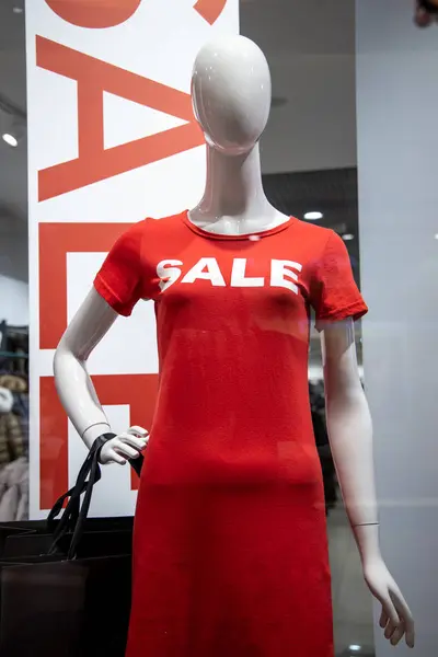 Bazı mankenler bir İtalyan giyim ve moda mağazasının vitrininde üzerinde "satış" yazan kırmızı bir gömlek giyer. Ocak ayındaki kış satışları sırasında. — Stok fotoğraf