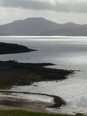 Loch Dunvegan Bulutların arasından kırma ve loch su üzerinde parlayan güneşi ile bir burun Coral beach, Isle of Skye, yukarıda alınan Macleod'ın bâkire doğru karşısında görüntülemek  