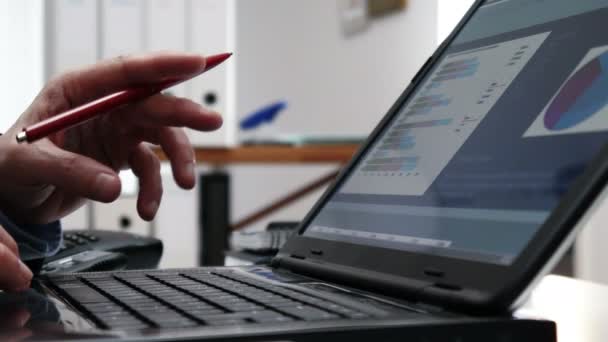 Бизнесмен проверяет фондовый рынок за своим ноутбуком - 4k — стоковое видео