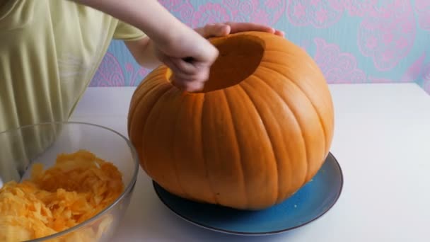 Cadılar Bayramı. Çocuk elinde bir jack o fener yapmak için bir kabak içi boş — Stok video