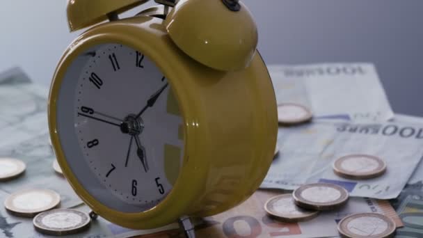 Relógio despertador em moedas e notas — Vídeo de Stock