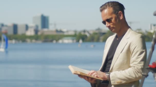 An office worker takes a break and enjoys a summer day with a book — Stock Video